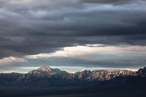 mountain range mountain under nimbus cloud cloud